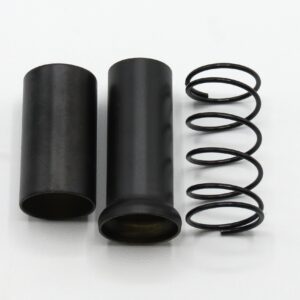 Black cylindrical tubes with a coiled spring laid out on a white surface, likely shock absorber parts.